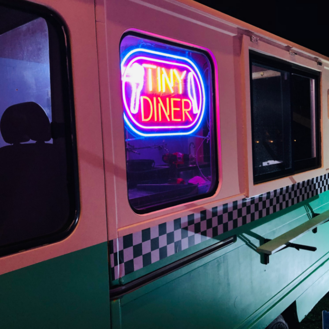 Enseigne néon LED personnalisable style diner rétro installée sur une caravane vintage, exemple de création de texte néon sur mesure