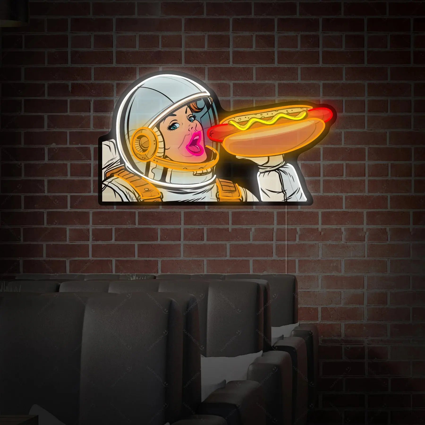 Enseigne néon LED pop art représentant un astronaute tenant un hot-dog lumineux, installée sur un mur en briques au-dessus de sièges de cinéma, décoration murale colorée.