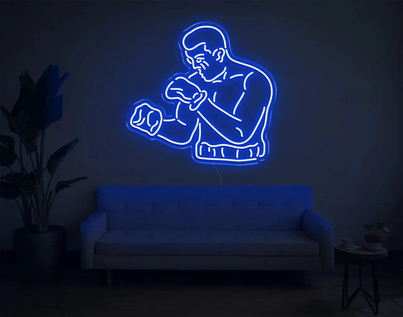 Lampe murale néon LED bleue représentant un boxeur, créant une ambiance sportive DIY au-dessus d’un canapé
