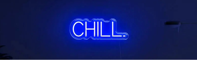 Enseigne néon LED CHILL bleue au-dessus d’un canapé moderne, créant une ambiance lumineuse DIY relaxante.