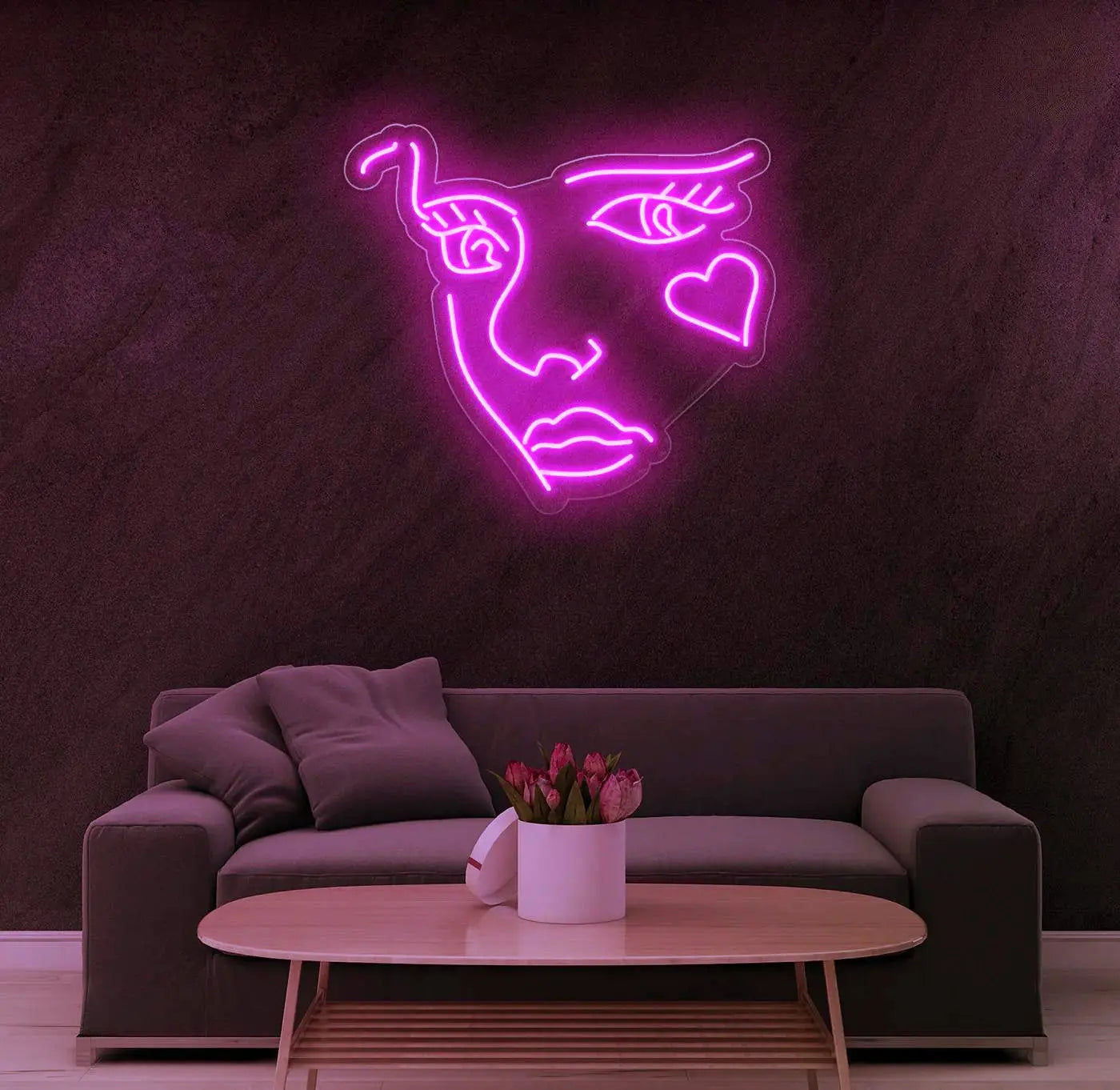 Néon LED visage abstrait rose utilisé comme éclairage décoratif principal dans un espace de vie moderne.