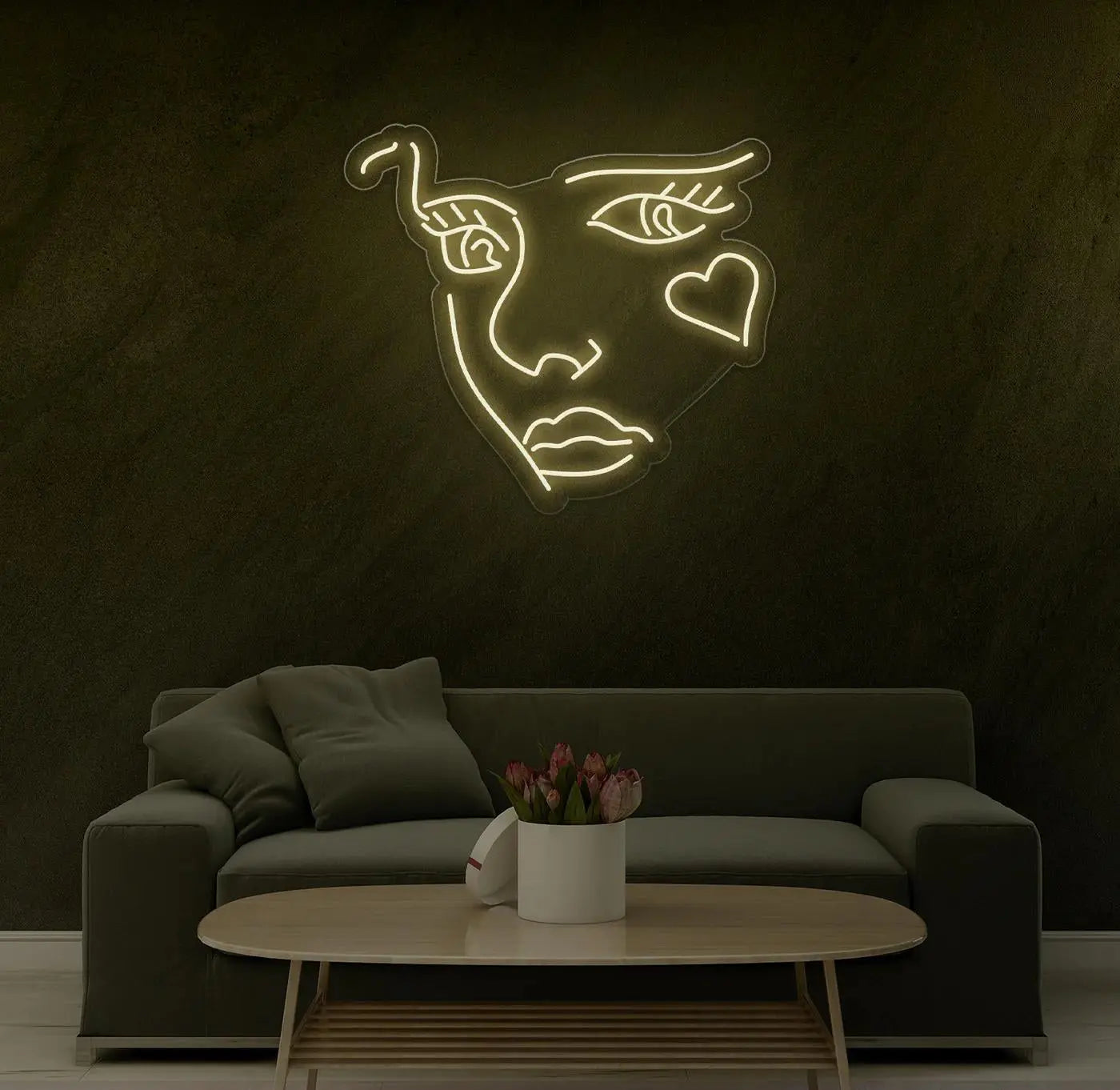 Néon LED visage abstrait blanc chaud installé au dessus d’un canapé, sublimant une décoration intérieure minimaliste.