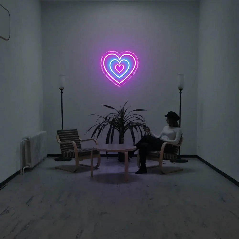 Néon mural en forme de cœur superposé violet et bleu diffusant une lumière douce dans un intérieur contemporain minimaliste.