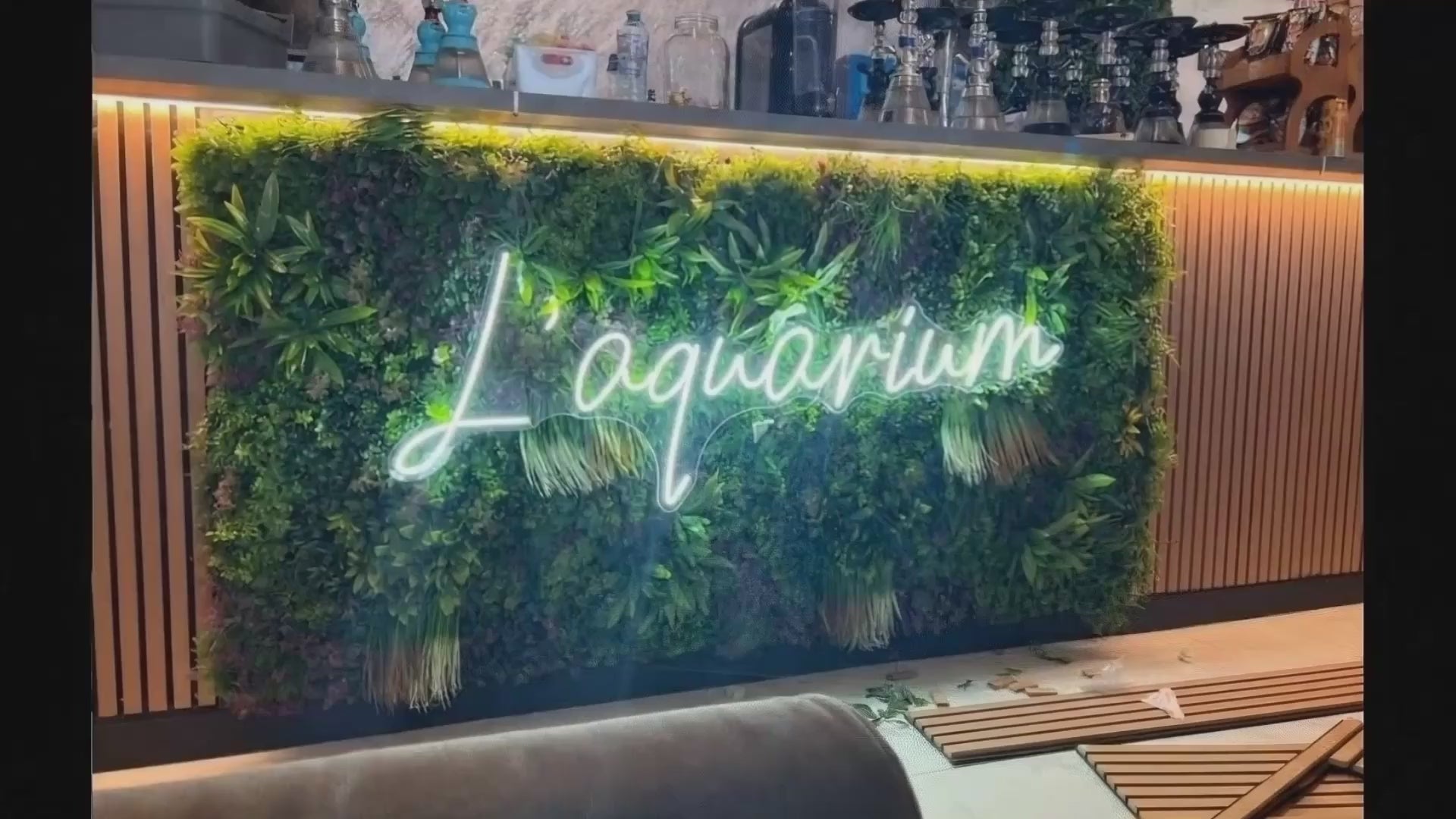 Enseigne néon LED script blanche sur mur végétal pour décoration professionnelle
